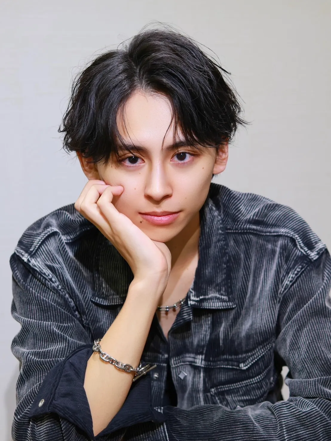 黒髪で緩めのアップバングスタイルの男性モデル