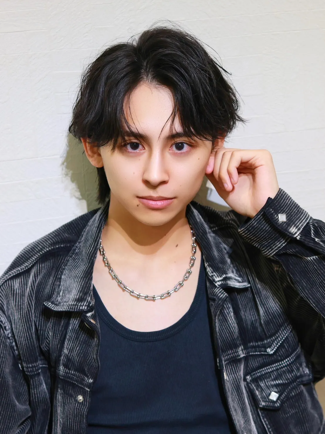 黒髪で緩めのアップバングスタイルの男性モデル